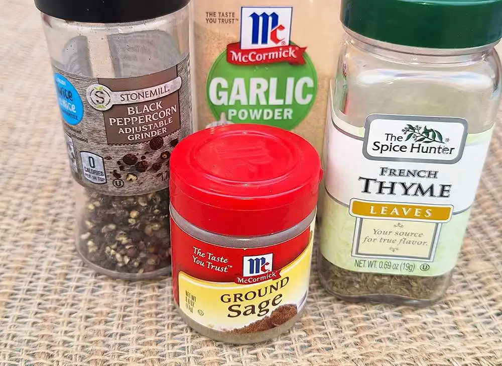 A jar of thyme, ground sage, garlic powder and black pepper to make low sodium sausage.