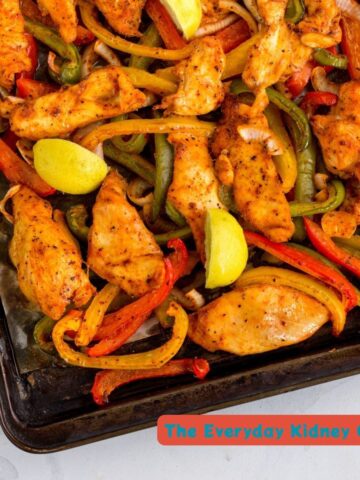 chicken fajitas on a sheet pan with lime wedges